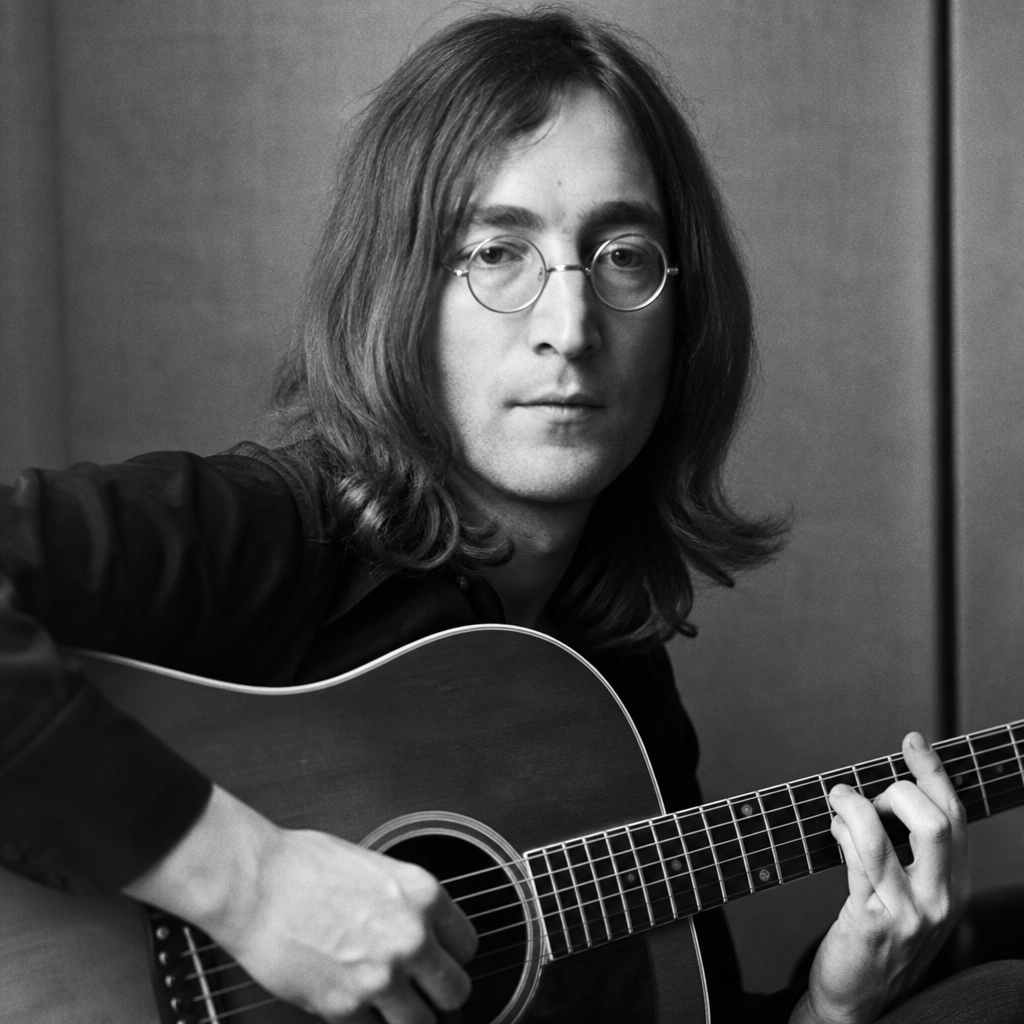 John Lennon in a contemplative black-and-white portrait with acoustic guitar