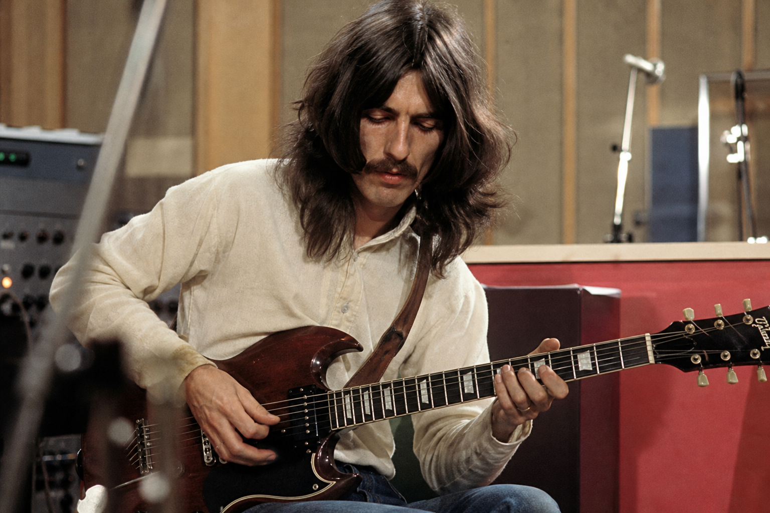 George Harrison playing guitar in a studio session, editorial style