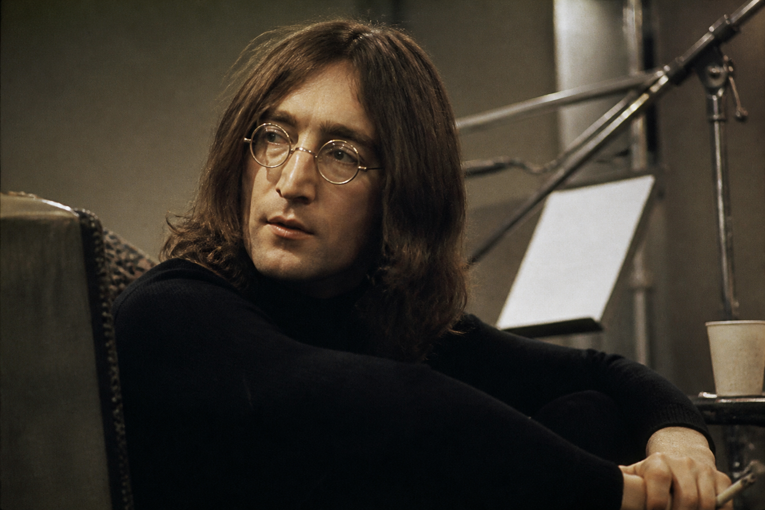 Editorial portrait of John Lennon in the late 1960s, contemplative studio atmosphere