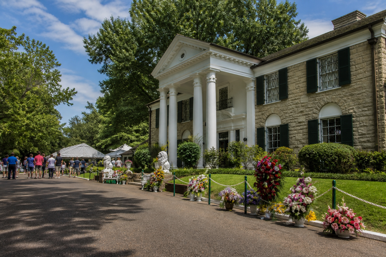 Graceland exterior with visitors and flowers
