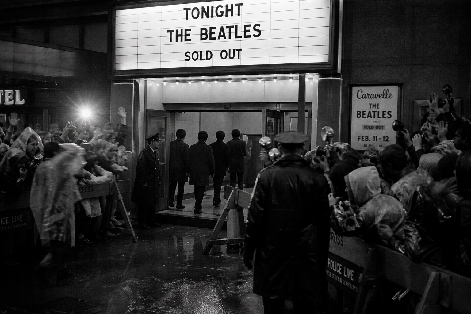 crowd barriers and camera flashes outside a concert venue