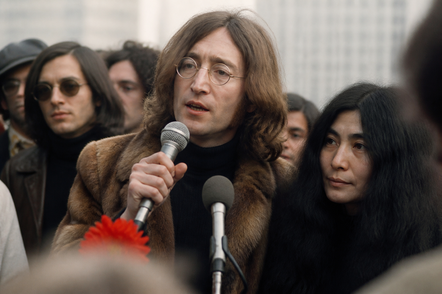 John Lennon speaking at an anti-war event with Yoko Ono nearby