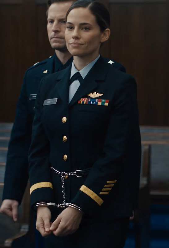 005. “Siga sonriendo, general”, dijo la capitana Elena Vance mientras la policía militar la conducía hacia la mesa de defensa.